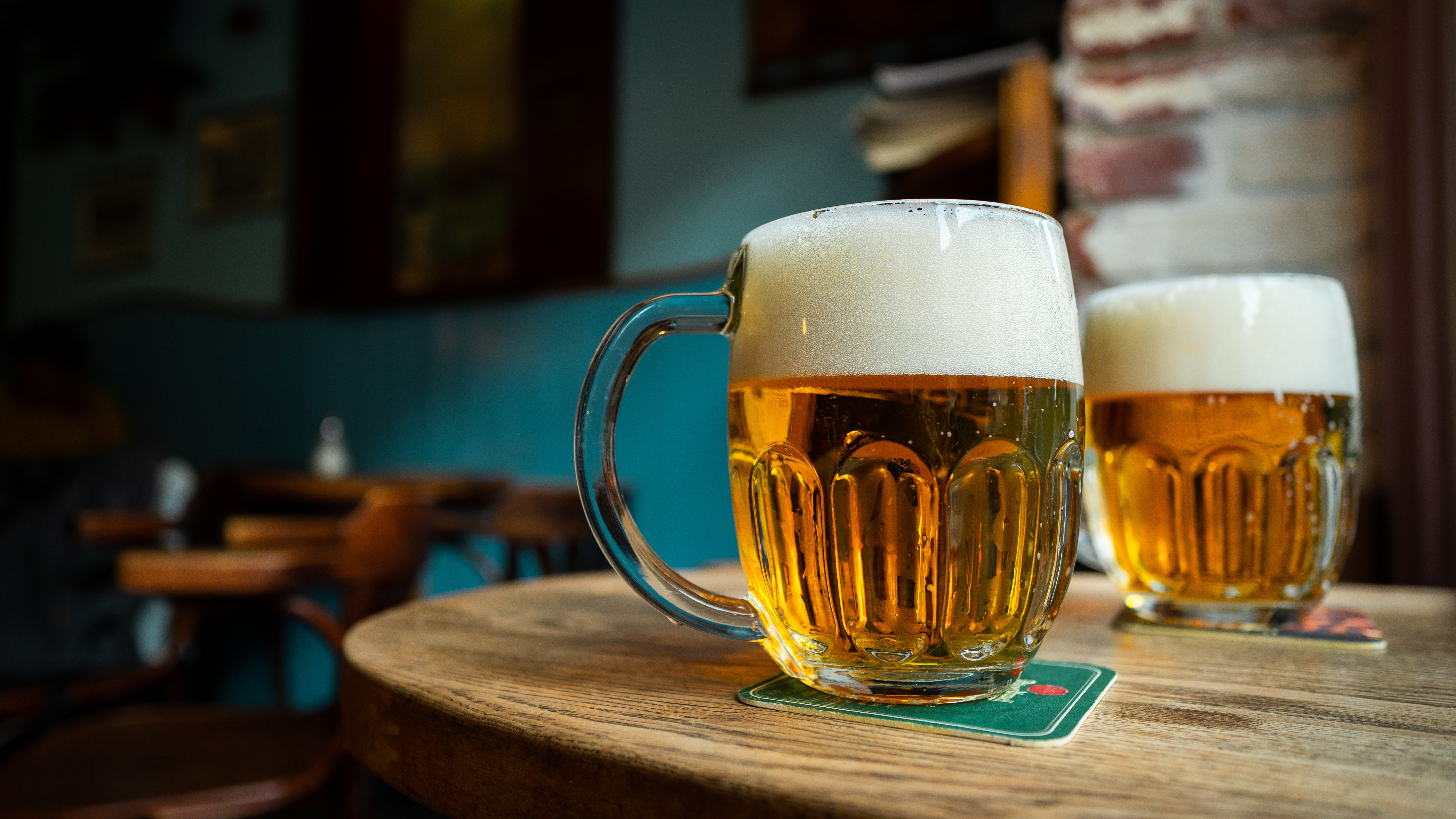 Pilsner Urquell being served in branded Pilsner branded mugs.